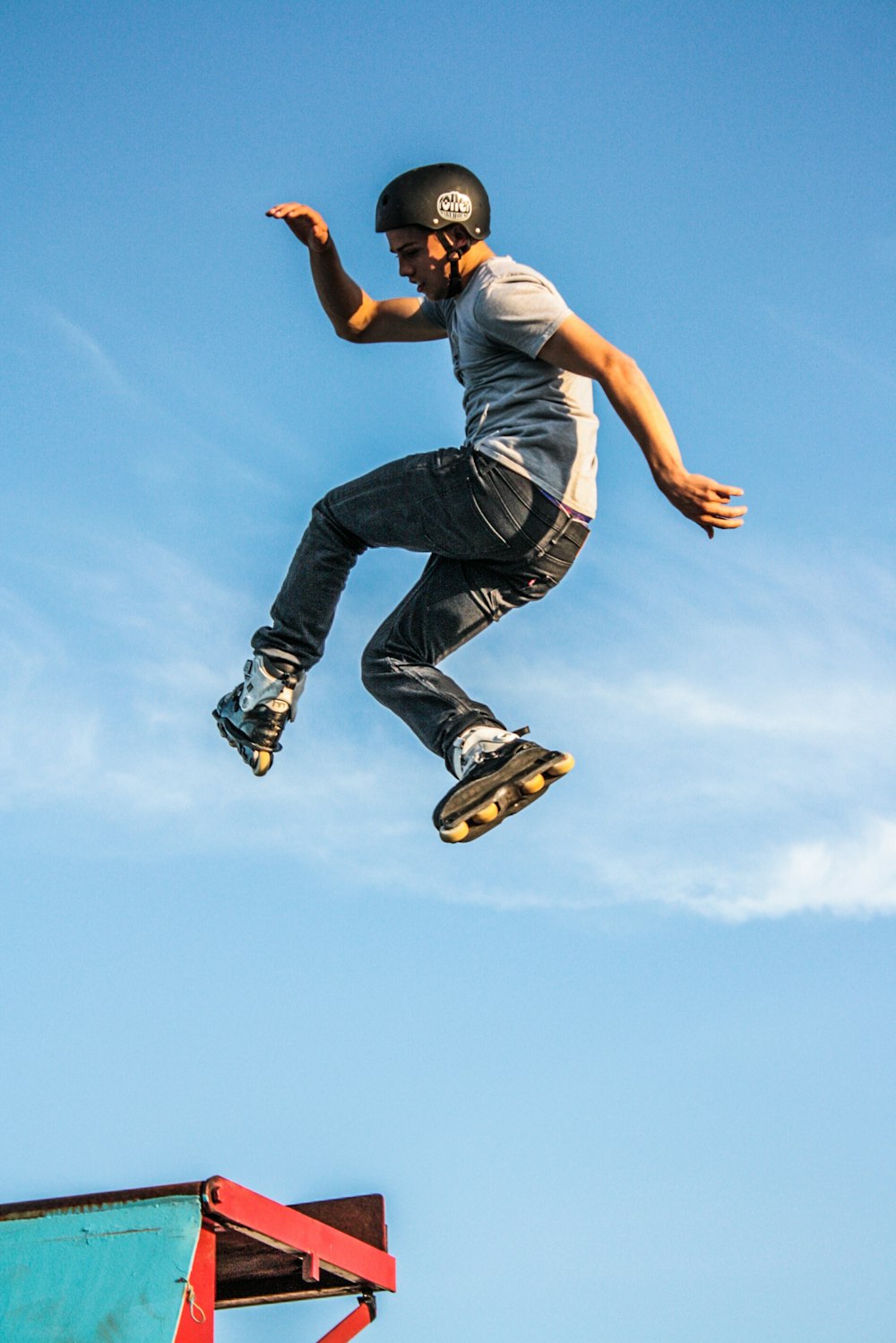 homem na camiseta branca fazendo um truque de patins no ar