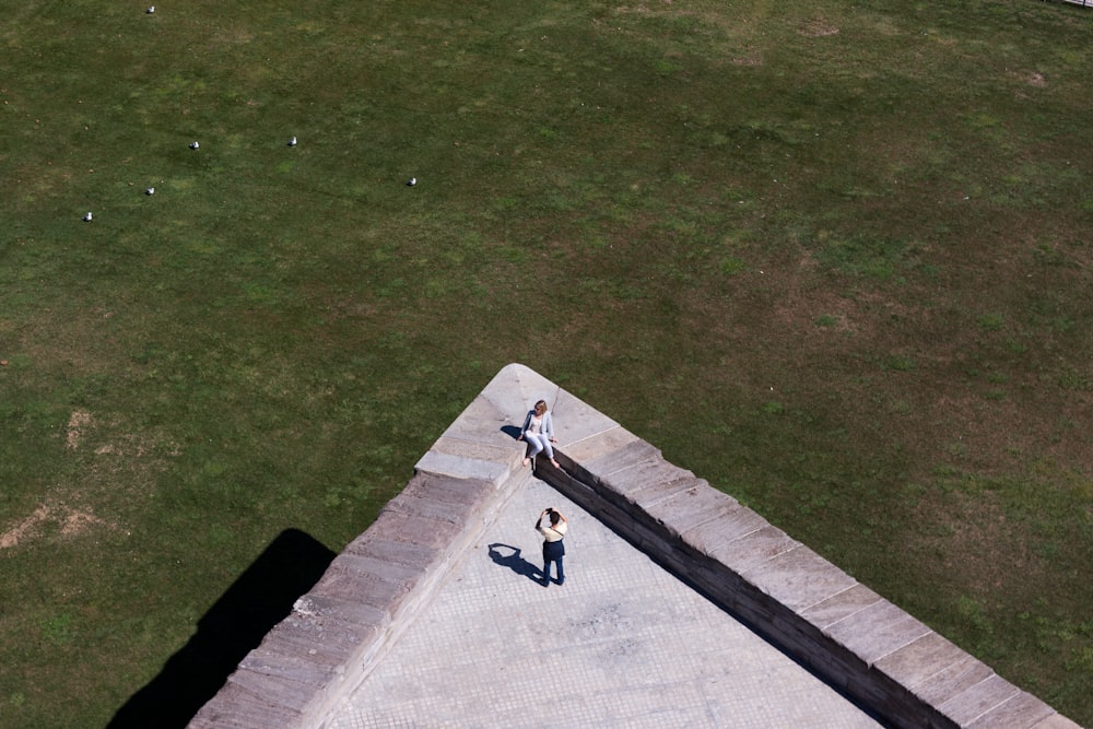 aerial photo of two person taking photo on top of building