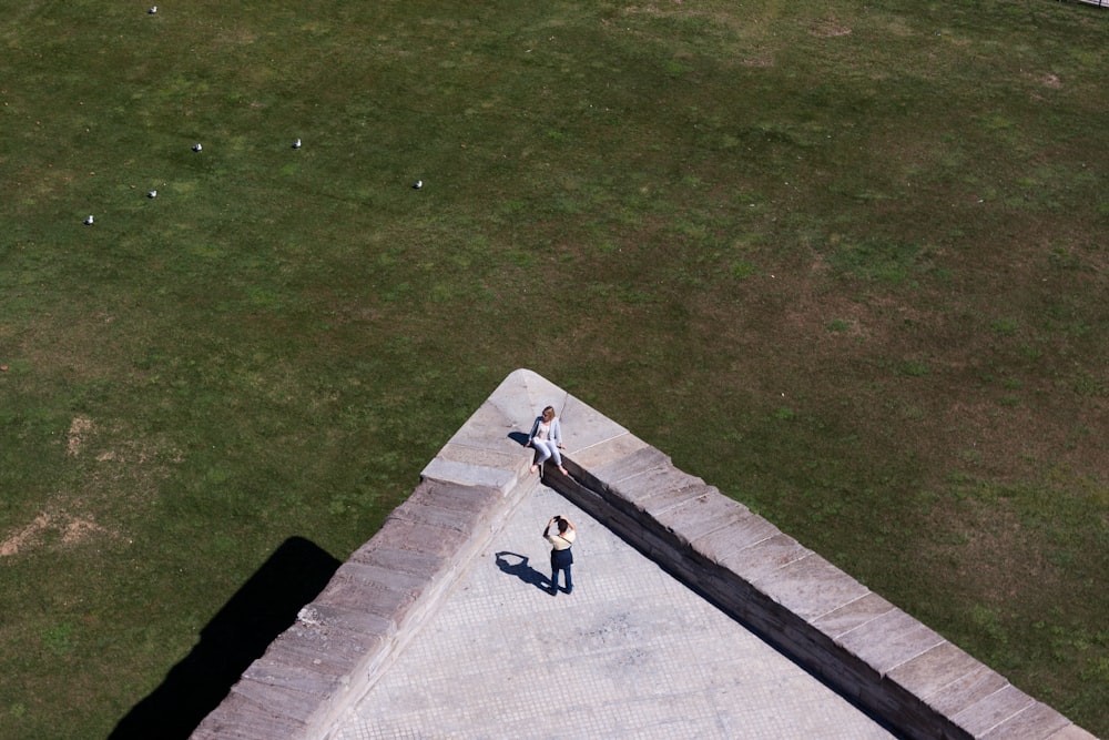 foto aérea de duas pessoas tirando foto no topo do prédio