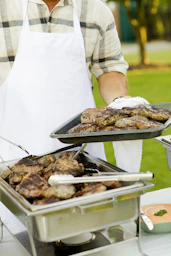 person holding tray filled with grilled meat