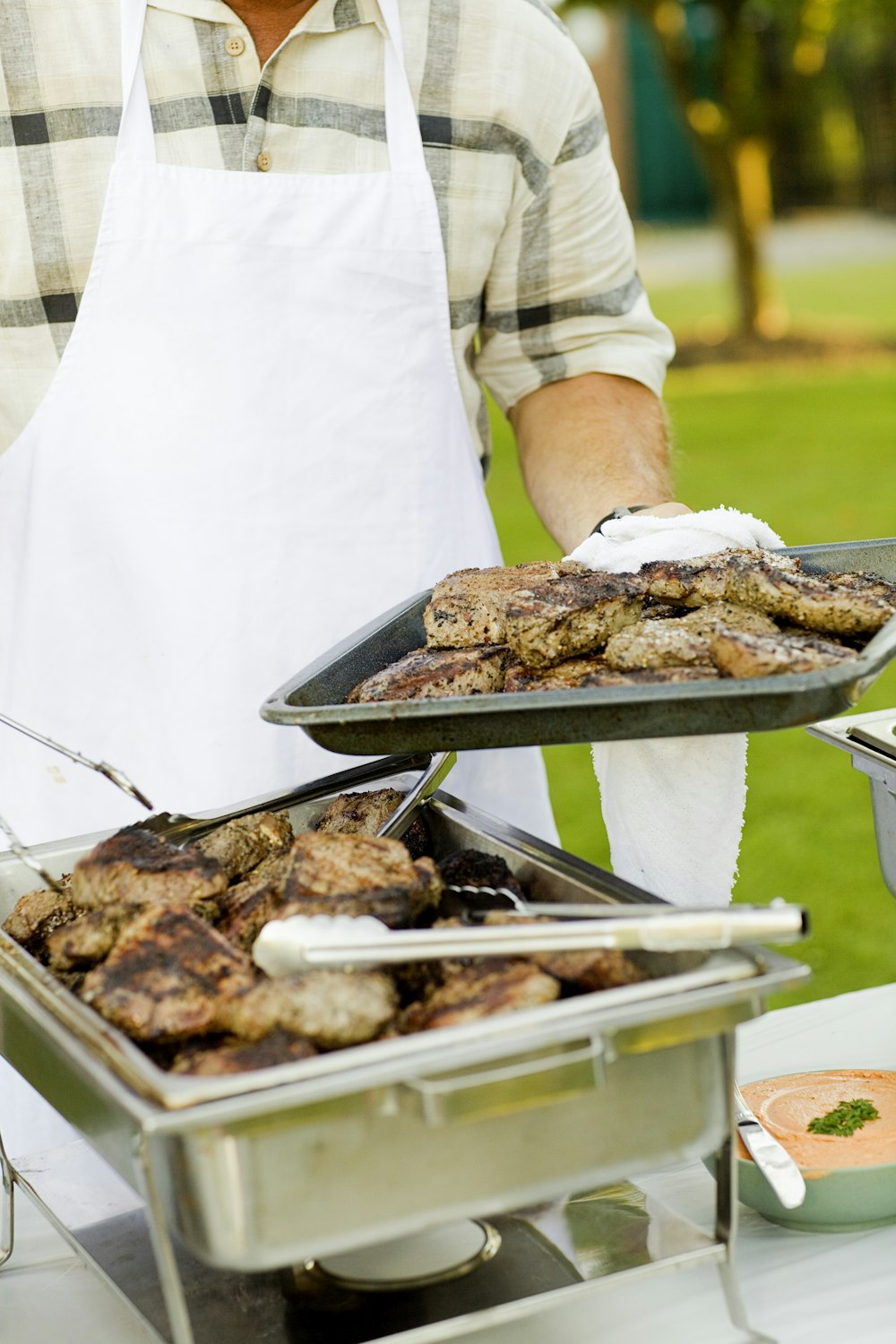 person holding tray filled with grilled meat