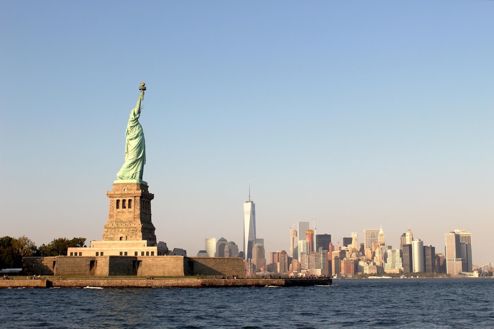 person taking photo of Statue of Liberty