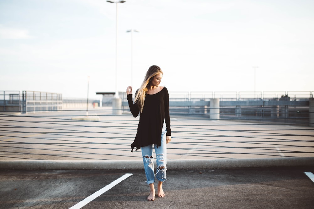 Femme debout sur un trottoir en béton gris