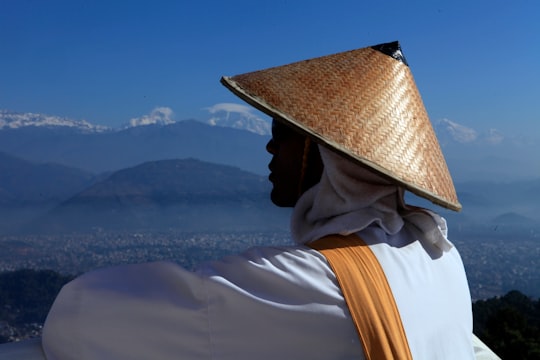 person wearing brown hat looking through during daytime in Pokhara Nepal