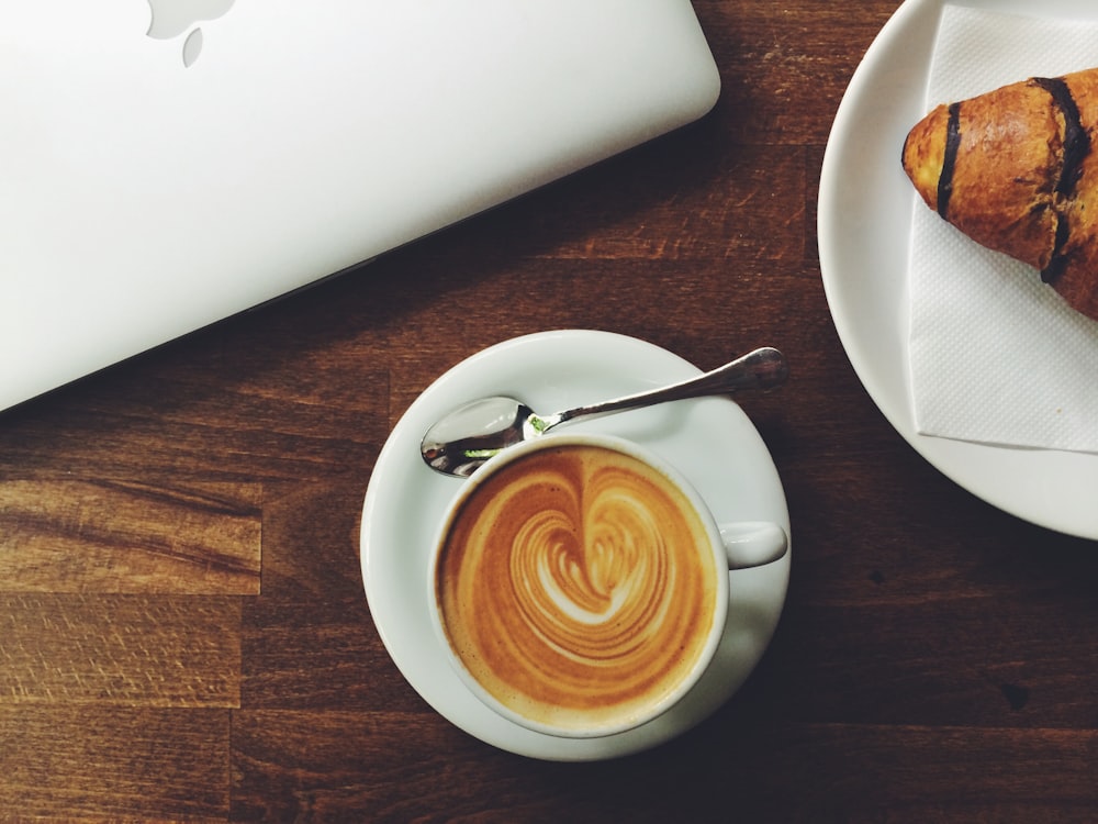 white ceramic espresso cup with saucer and spoon with heart form