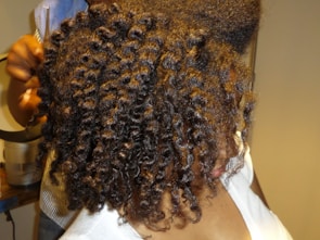 A close-up of shiny, healthy curls freshly styled at 12511 hair salon llc.