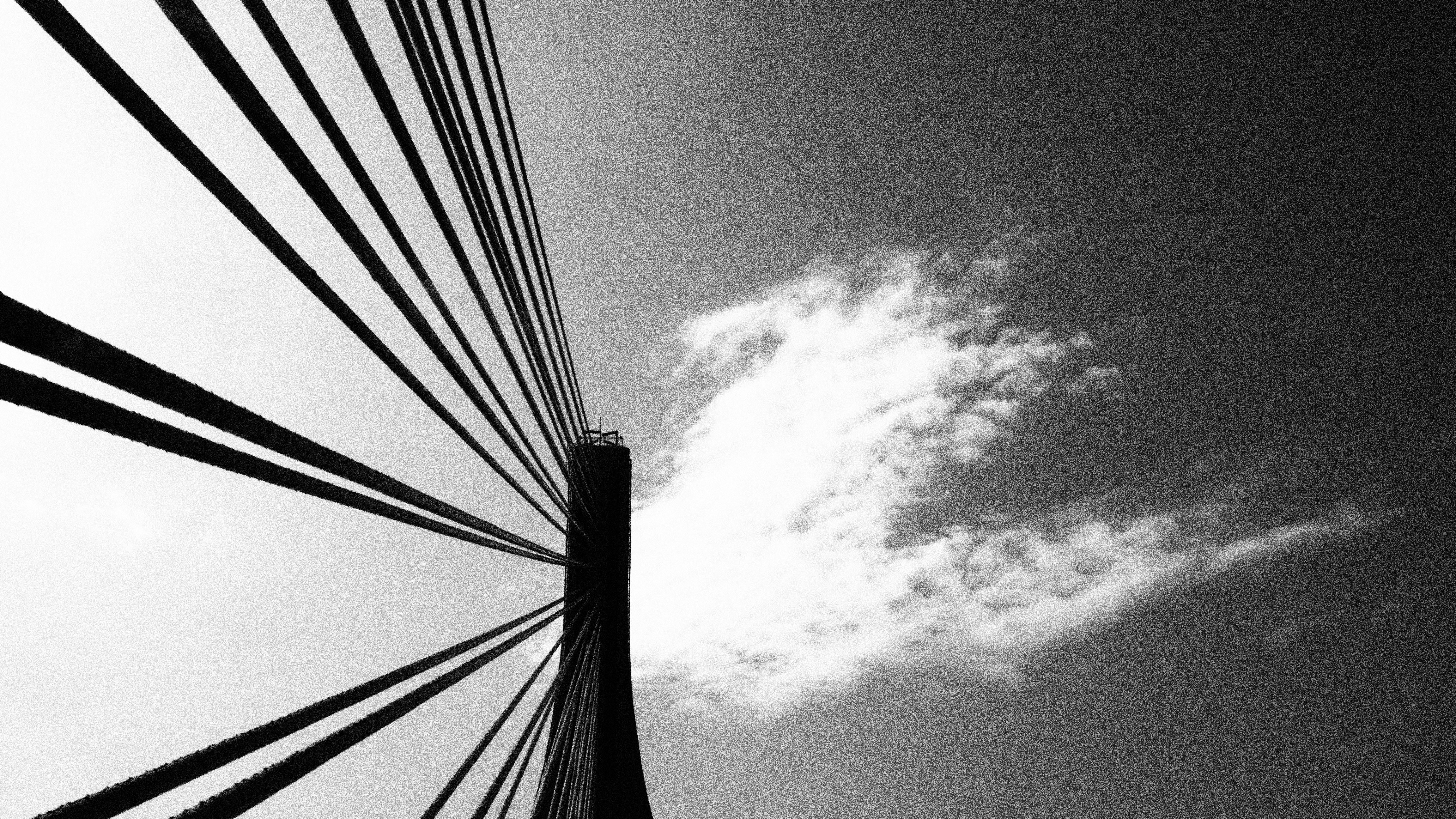 low angle photography of bridge wire under clouds