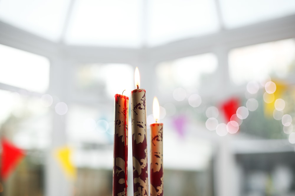 three brown-and-red candles on top of table