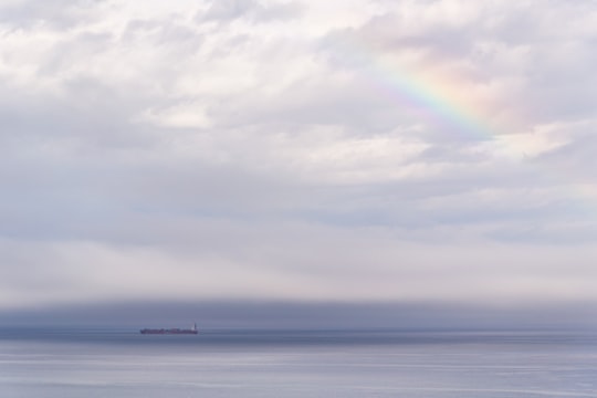 vessel on ocean under cloudy sky with rainbow in Port Angeles United States