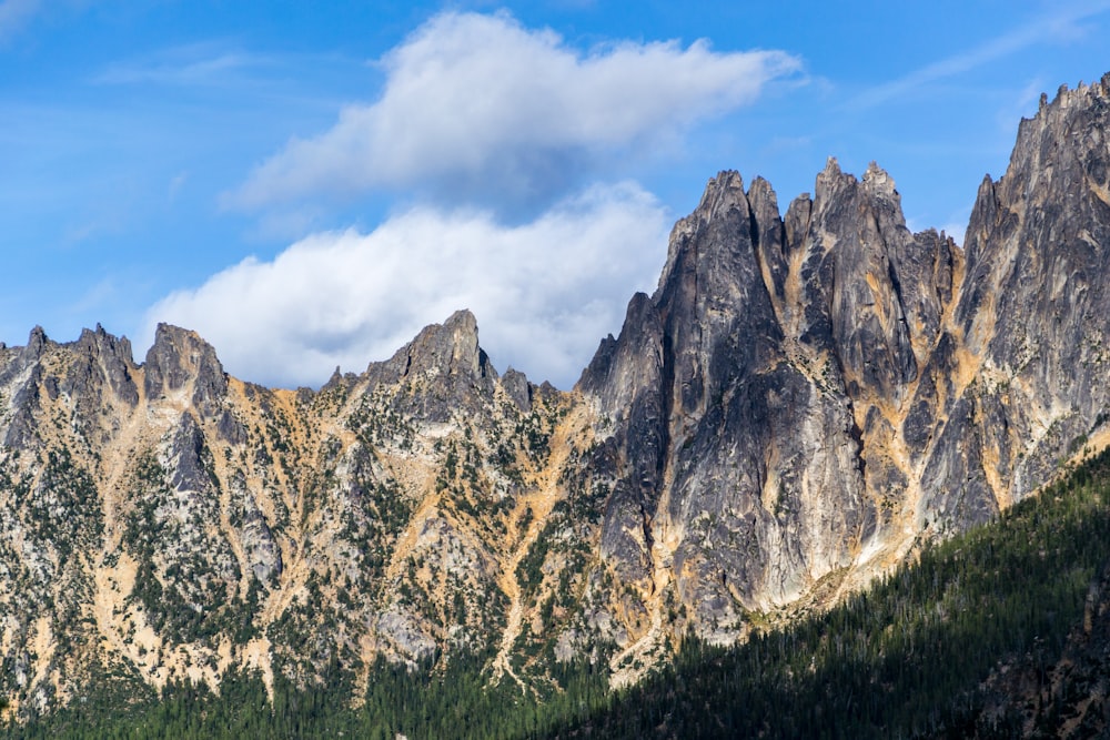 rock mountains under blue and white sky