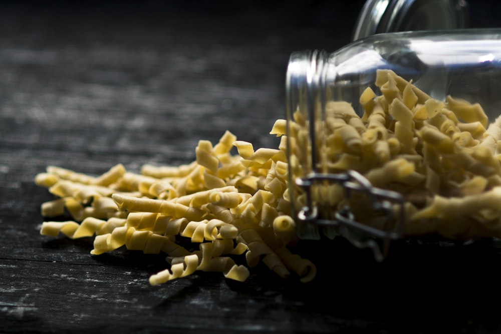 close up photo of yellow spiral pasta spilled jar