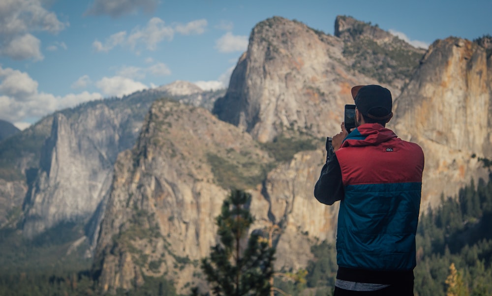 person taking photo of mountains during daytime