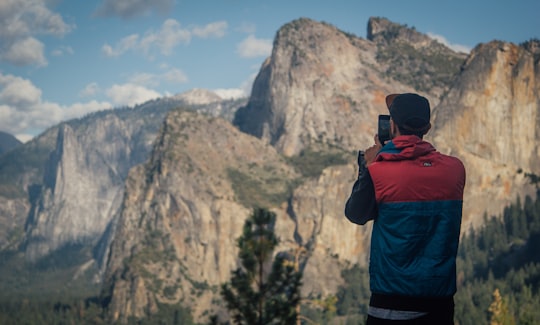 person taking photo of mountains during daytime in Yosemite National Park United States