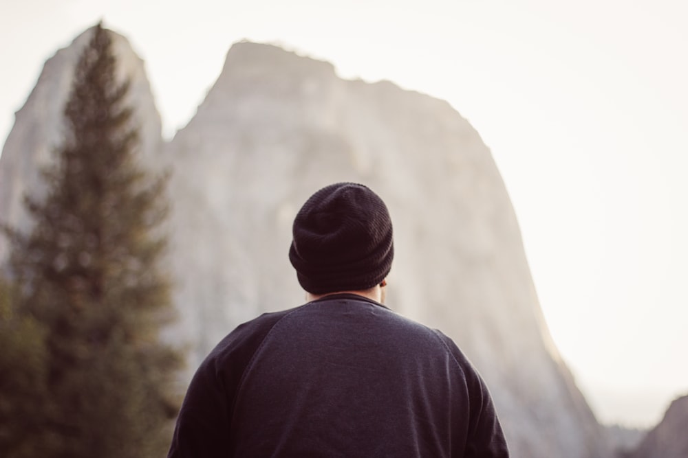 man wearing blue top facing mountain