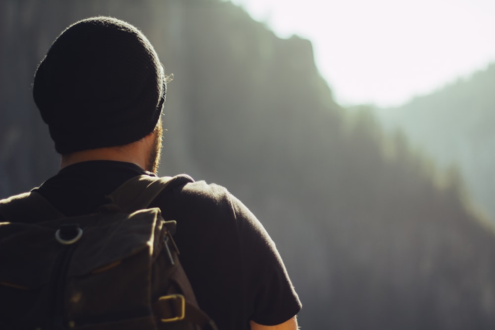 The back of a man wearing a backpack and a beanie in Yosemite National Park