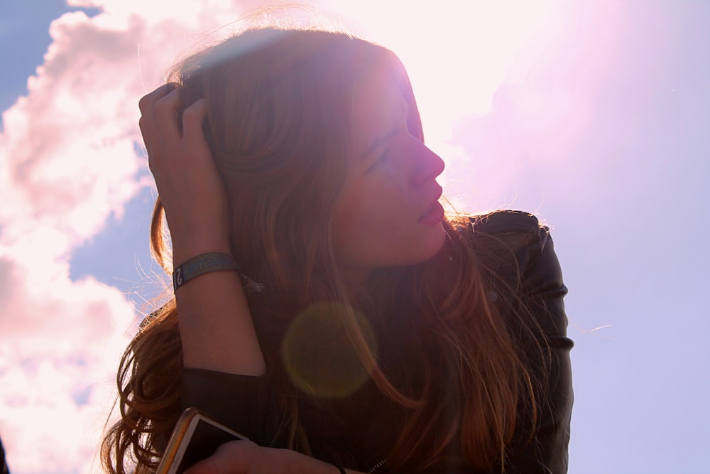 woman in black top holding her hair looking up