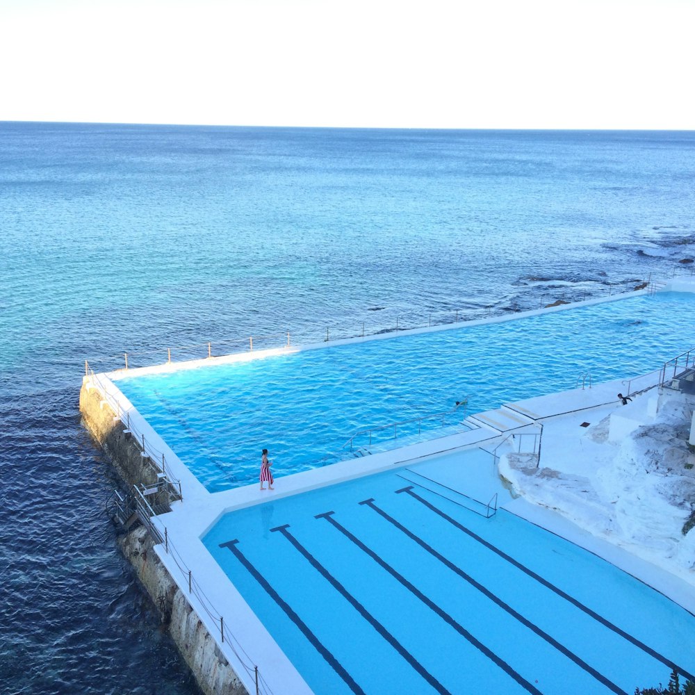 Person, die neben dem Pool spazieren geht