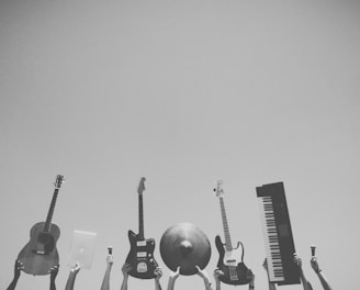 grayscale photo of people holding assorted music instruments