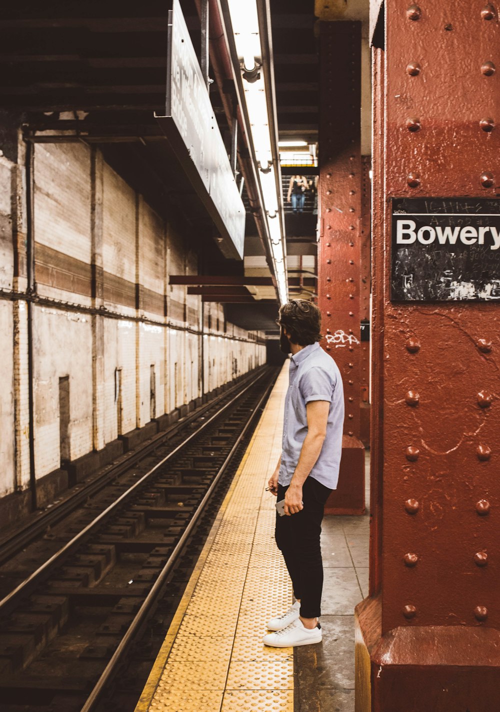 man standing beside subway platform