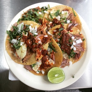 Colorful plate of handmade tacos topped with cilantro and onions.