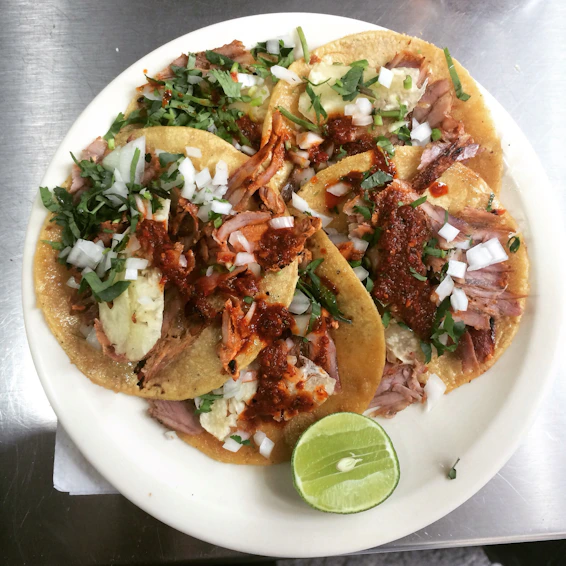A vibrant plate showcasing spicy tacos with colorful salsa and fresh lime wedges.