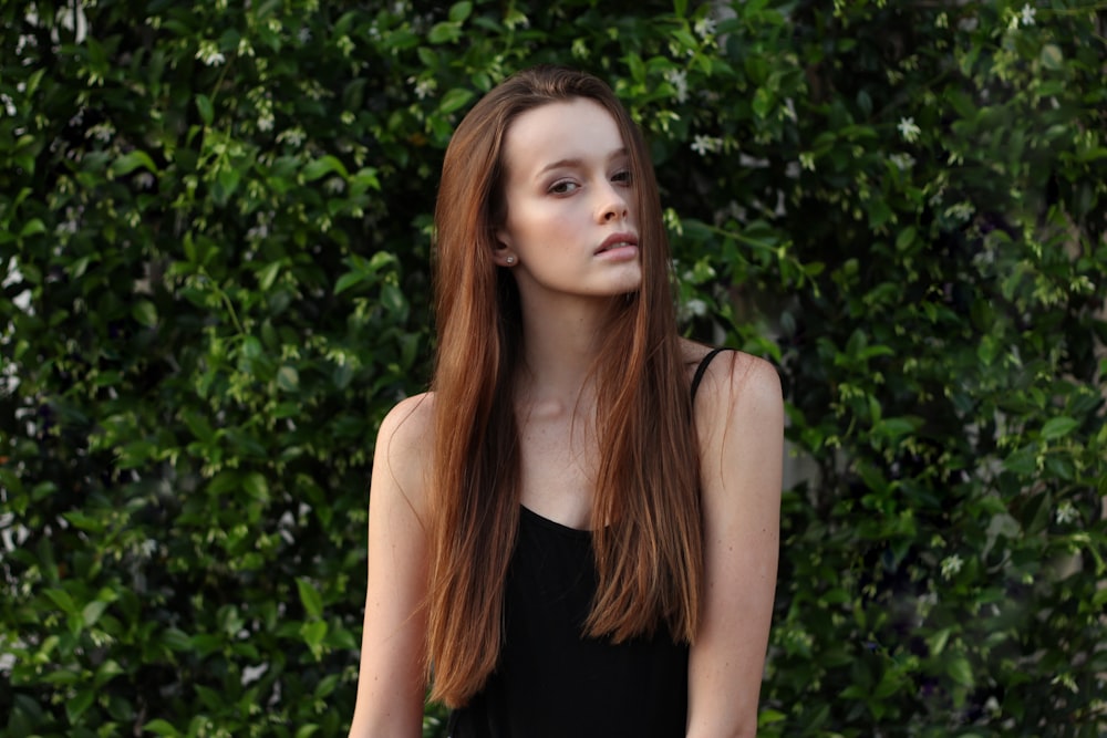 woman wearing spaghetti strap top in front of bush