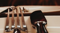 Close-up of polished silverware set neatly on a rustic wooden table.