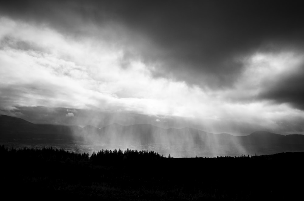 Une photo en noir et blanc de nuages de pluie abondante au-dessus d’un lac