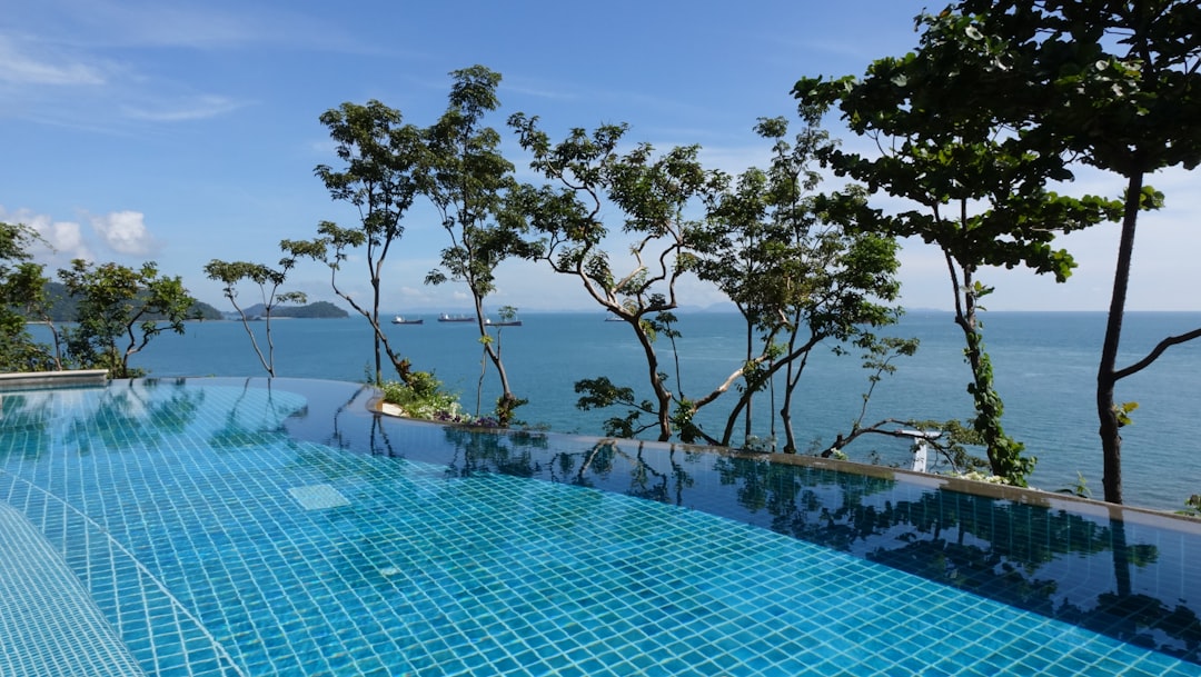 infinity pool with background view of open sea at daytime,