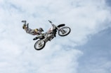 Beau Manley demonstrating a freestyle motocross trick mid-air with a clear blue sky backdrop.