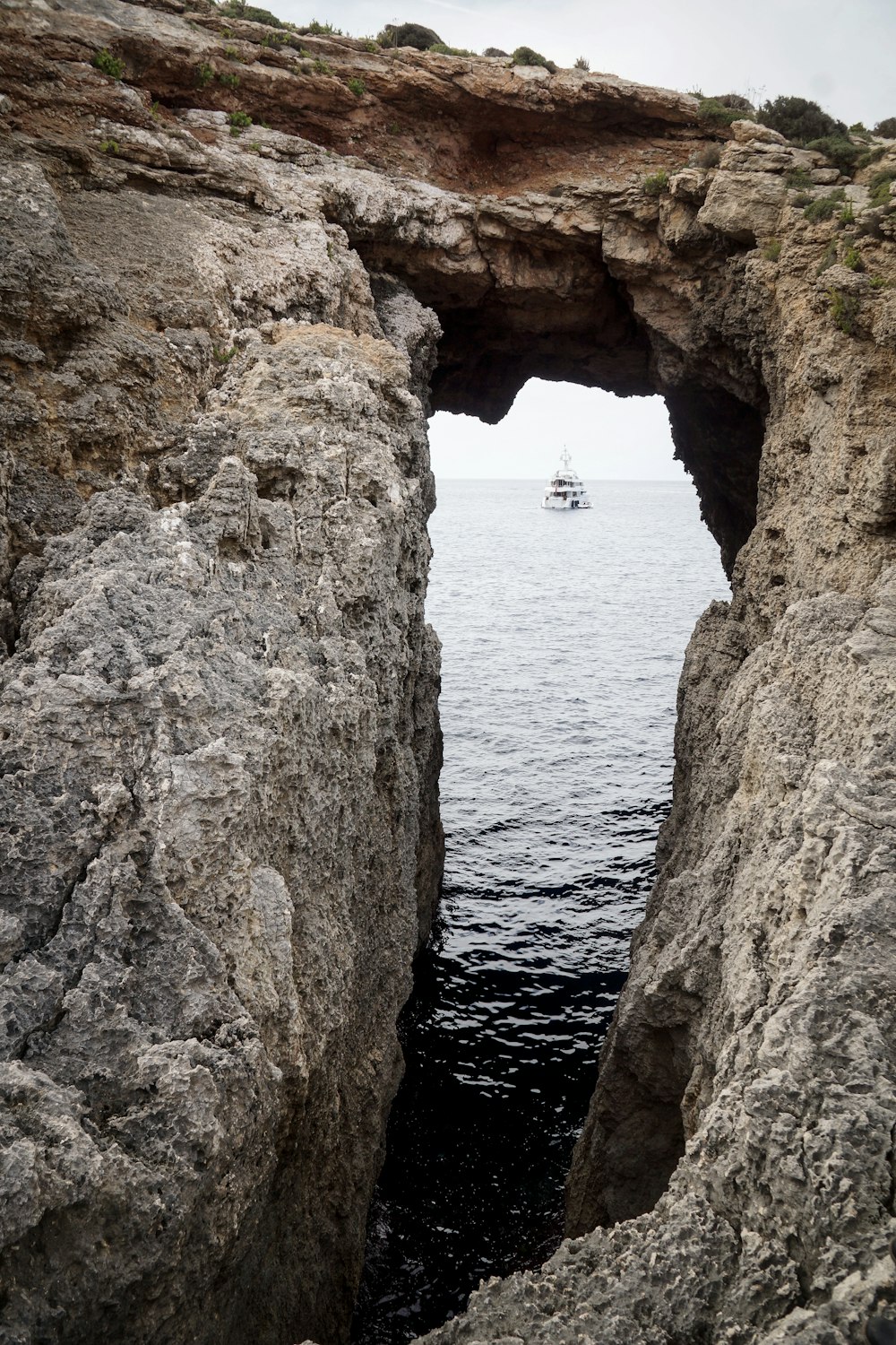Formación rocosa cerca del mar con velero