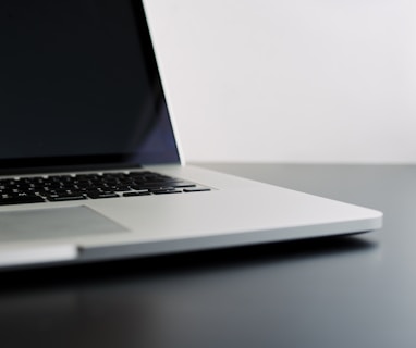 silver laptop computer on black table