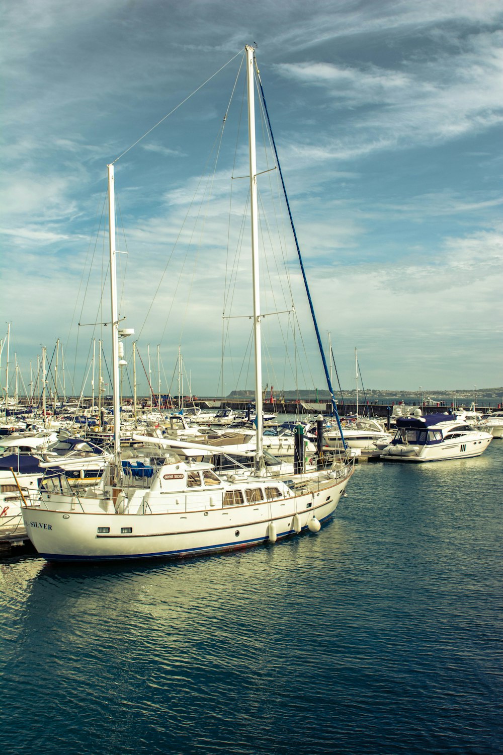 docked boat on water under blue and white cloudy sky