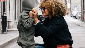 woman holding kid at the street