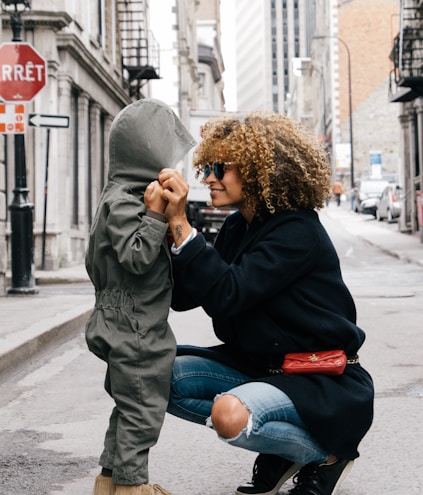 woman holding kid at the street