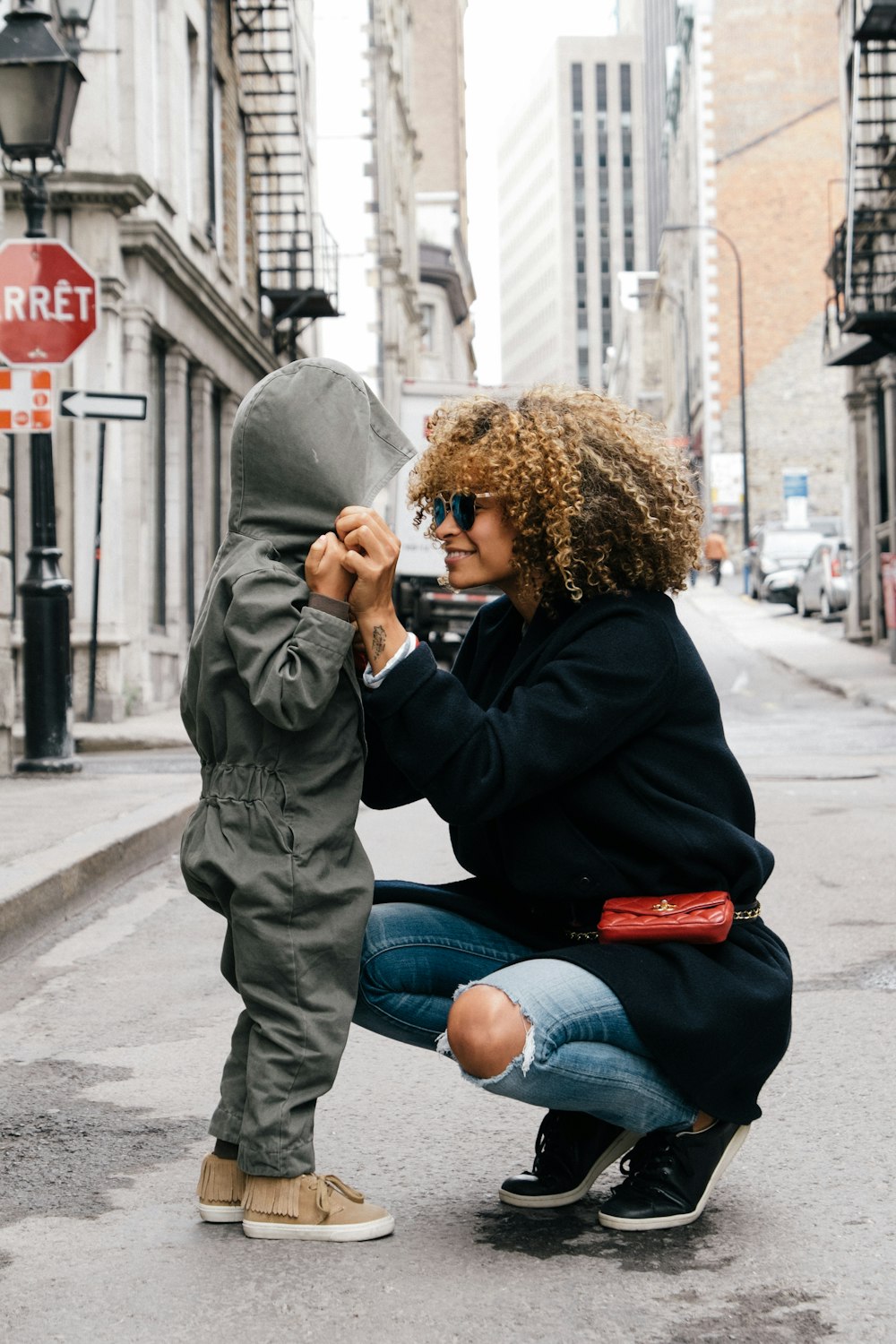 mujer sosteniendo a un niño en la calle