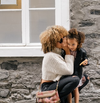 woman wearing white sweater carrying a daughter