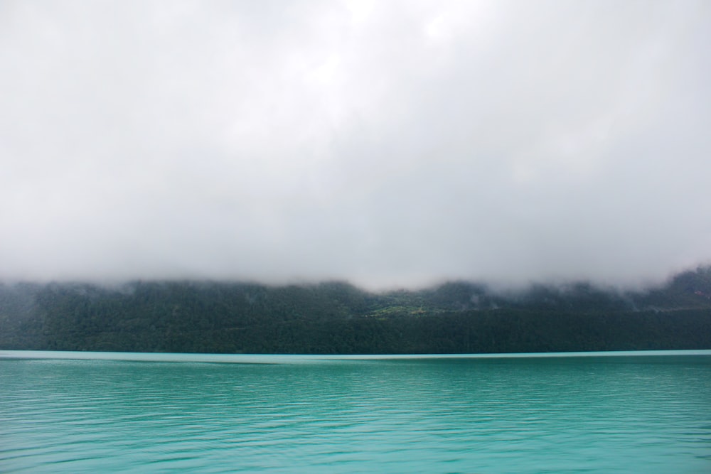 türkisfarbenes Wasser in der Nähe von Land mit Nebel