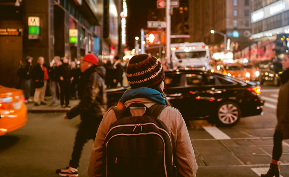 woman crossing highway during nighttime