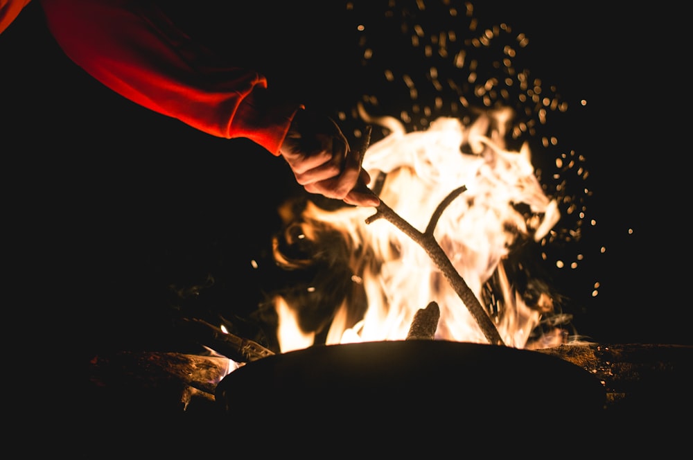 火の上で鍋をかき混ぜる人