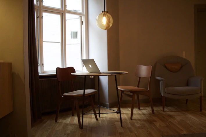 A sleek wooden folding table set up in a cozy living room corner