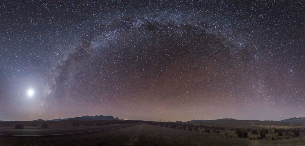 星でいっぱいの空の下の灰色のコンクリート道路