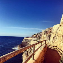 Scenic coastal hiking path with blue sea and rugged cliffs under a clear sky in northern Morocco.