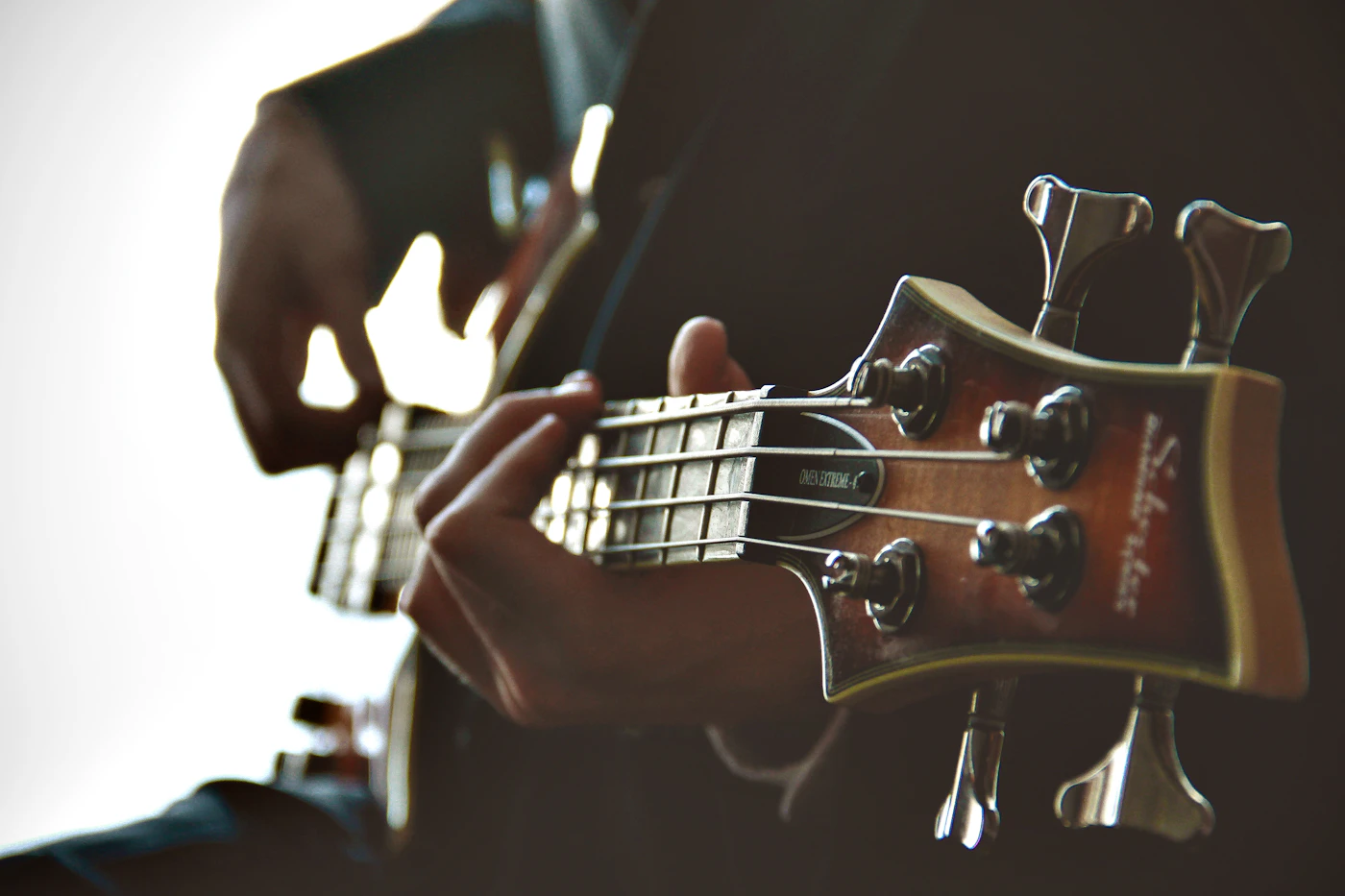 Hands adjusting strings on a guitar neck