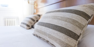 gray and black throw pillow on bed