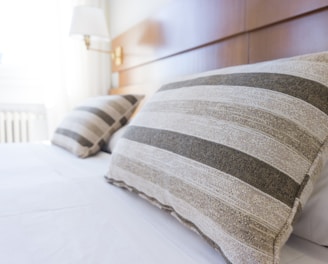 gray and black throw pillow on bed