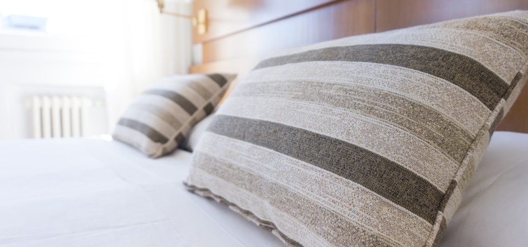 gray and black throw pillow on bed