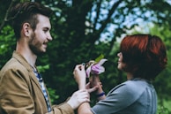 A Harborcare support worker sharing a light moment with a participant at a garden, surrounded by blooming flowers.