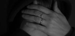 Hands gently touching soft, springy ringlets in a cozy indoor setting.