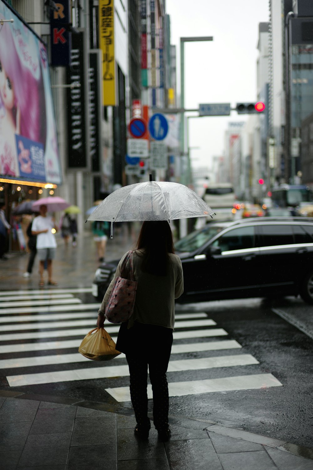 femme tenant un parapluie debout sur la voie du piédestal